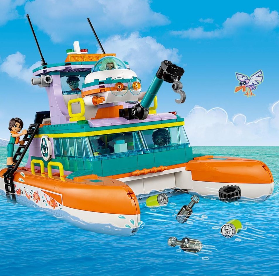 Toy boat set on water with a blue sky and cloud background