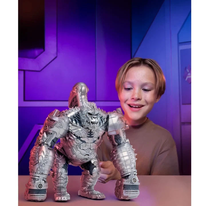 Young boy with the large silver Armorsaurs King Chrome figure on a table, surrounded by blue and purple lighting in a futuristic themed room.
