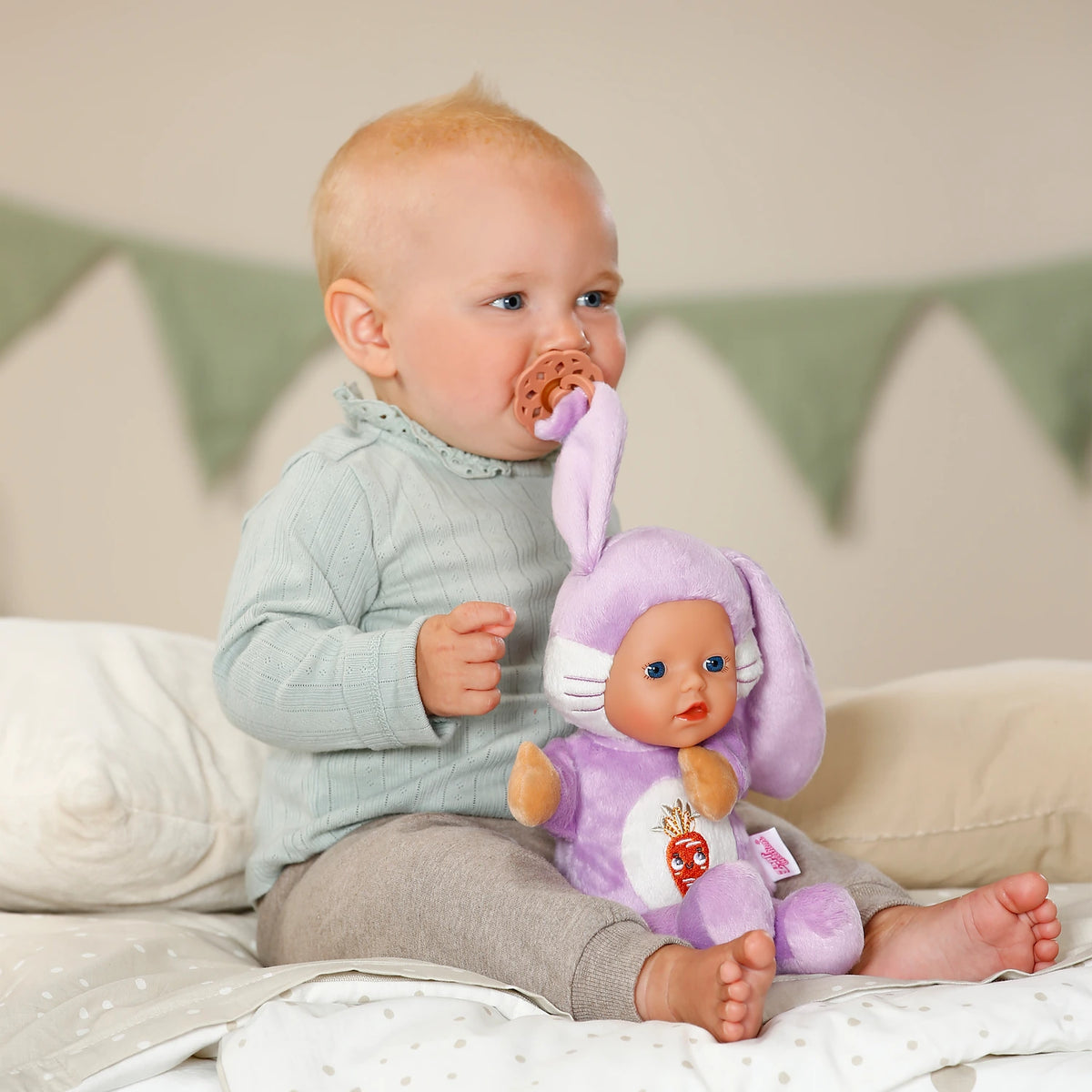 BABY born Funny Bunny beside baby with dummy attached to the bunny ear clip