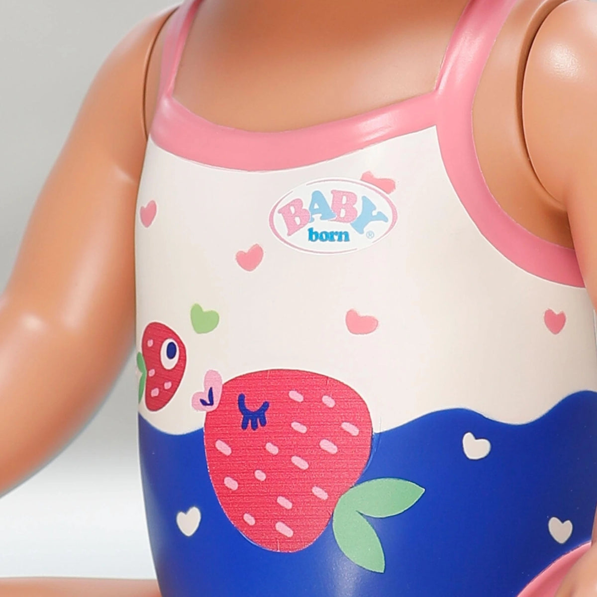 Close up of Baby Born Swimming Lizzie 30cm swimsuit with strawberry print and Baby Born logo