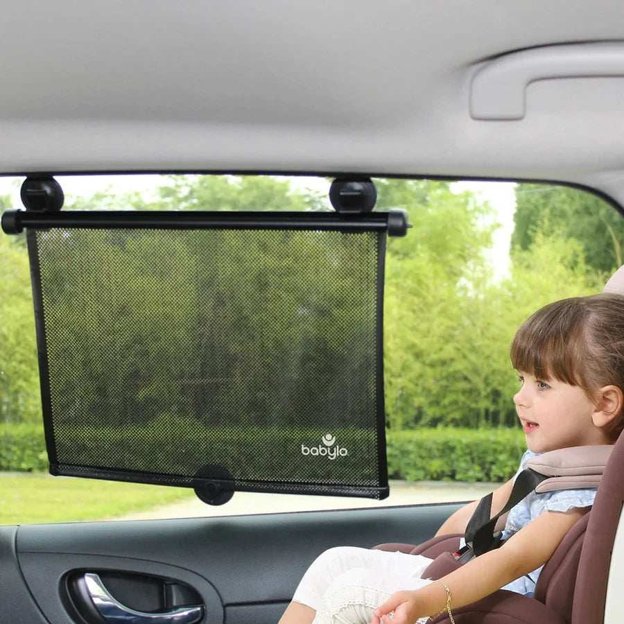Babylo roller sunshade attached to a car side window beside a child in a car seat