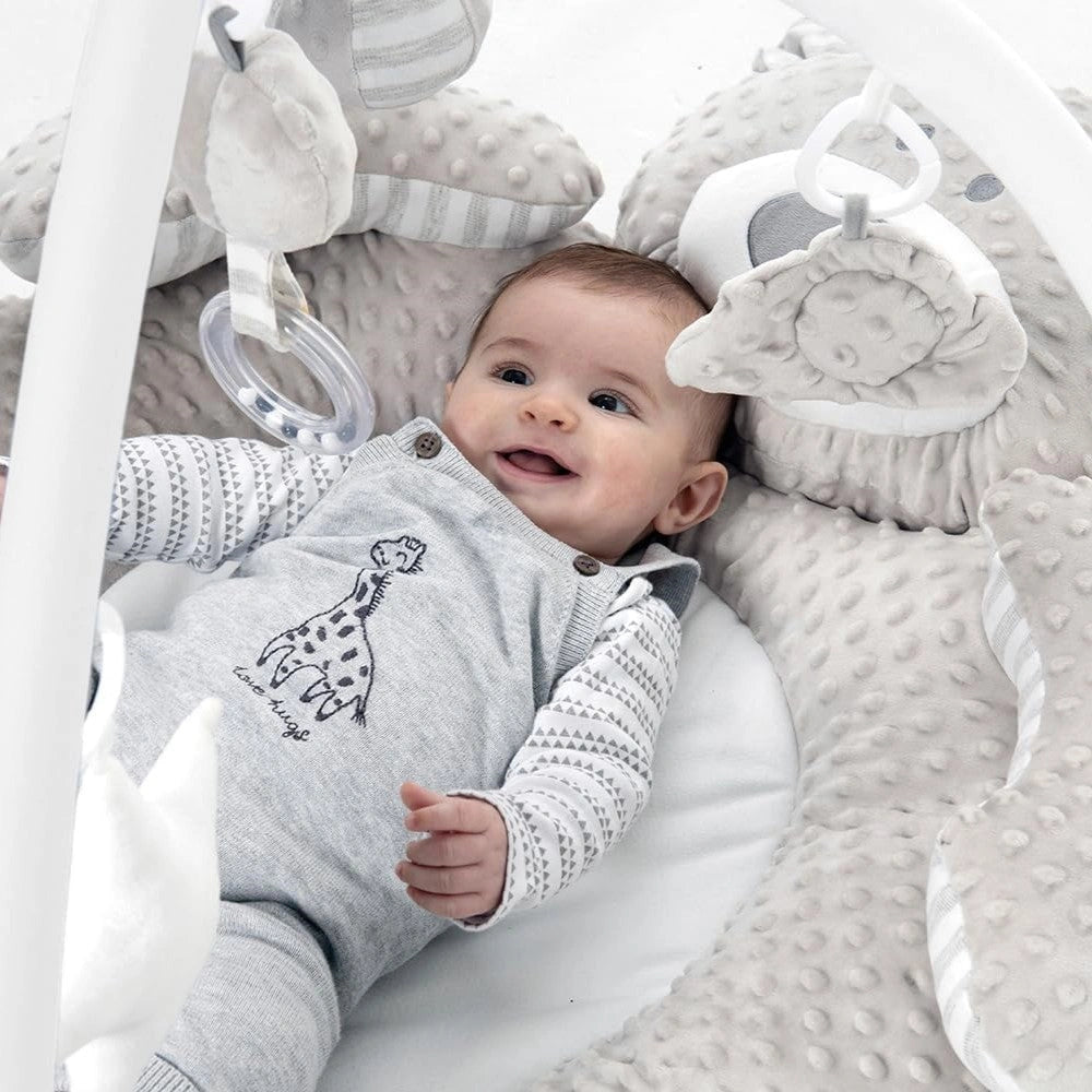 Close up of baby inside Babyzee Bear Necessities Play Gym reaching toward hanging plush toys with padded bear surround