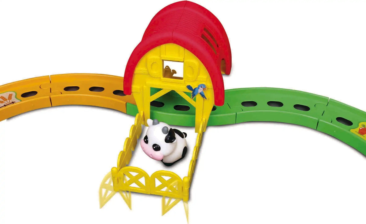 BB Junior farm tractor set close-up showing a cow beside a yellow barn and green track