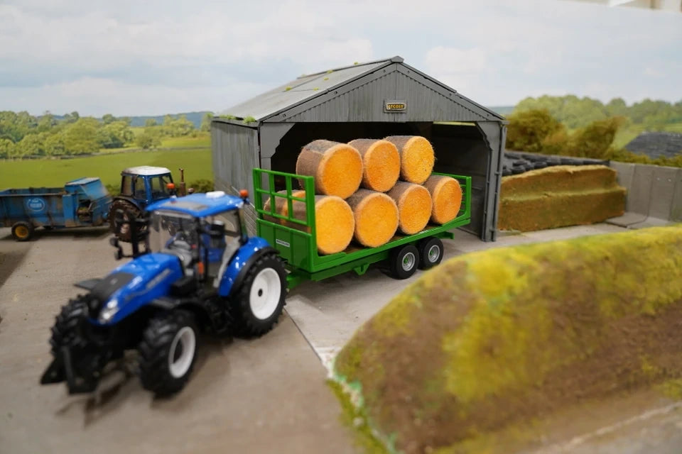 Britains 1:32 Flat Bed Trailer loaded with round bales behind blue tractor in farmyard scene