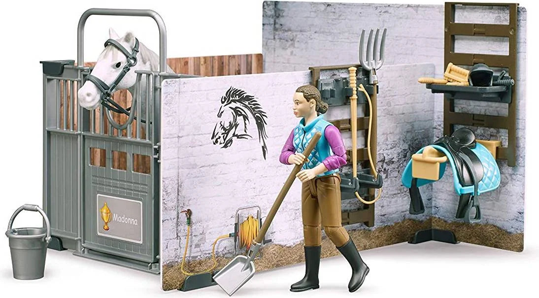 Rider figure cleaning the stable area while the white horse stands in the stall with accessories nearby