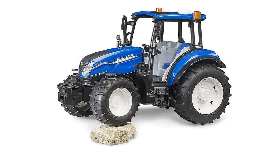 Bruder New Holland T5.120 toy tractor driving over rock with off-road tyres and front weight block in Ireland