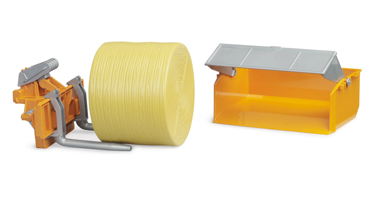 Bruder transport box in orange with grey raised lid beside a yellow round bale and orange bale forks on a white background