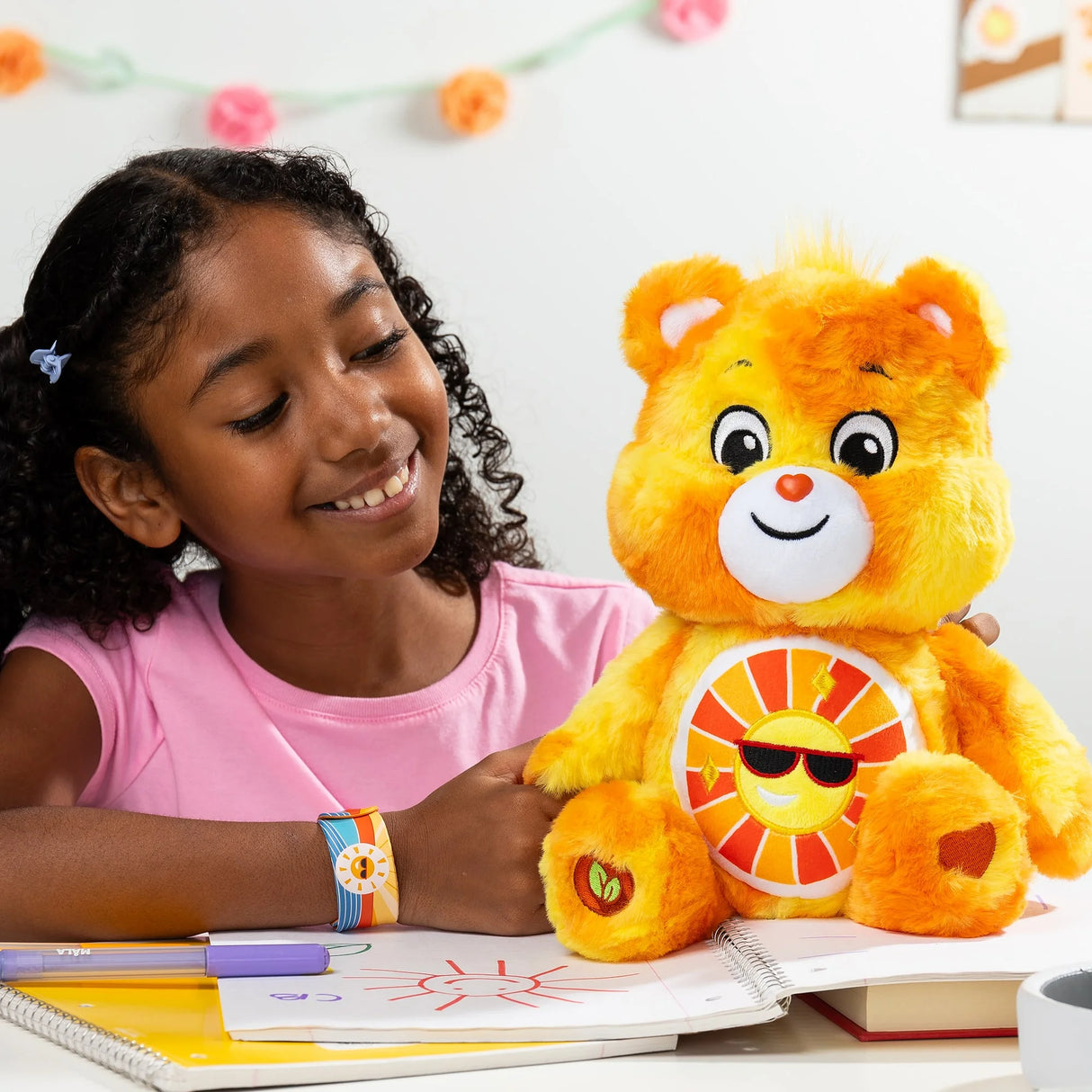 Child hugging Care Bears Color Splash Funshine Bear plush highlighting sunny yellow and orange fur in Ireland.