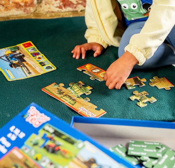 Child playing with Tractor Ted seasonal puzzles on a mat - Ireland