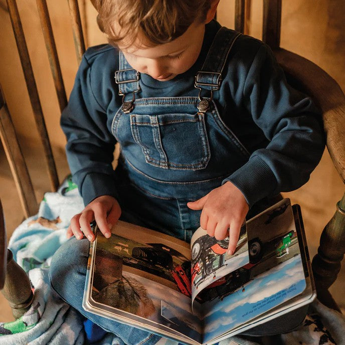 Child reading Tractor Ted Lift-the-Flap Book in Ireland indoors - Ireland