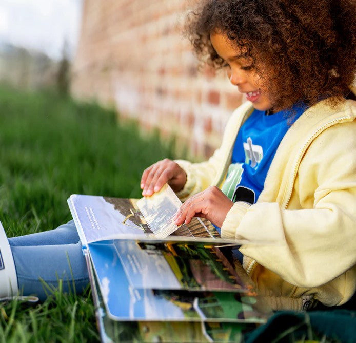 hild reading Tractor Ted Tractors and Machines Lift-the-Flap Book outdoors Ireland