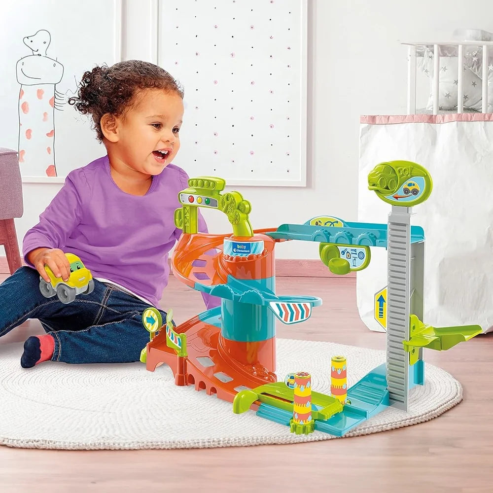 Smiling toddler playing with Clementoni Baby Fun Garage featuring colourful ramps and cars on a play mat in Ireland