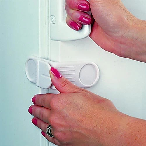 Clippasafe Fridge & Freezer Lock fitted to a white fridge door, showing press to lock mechanism held between door and frame by an adult hand