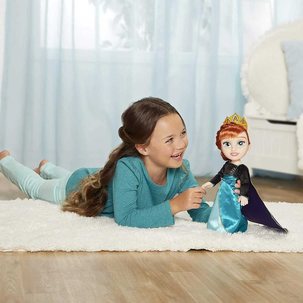 Child playing on floor with Disney Frozen Anna Toddler Doll dressed as Queen Anna with gown and tiara in Ireland.