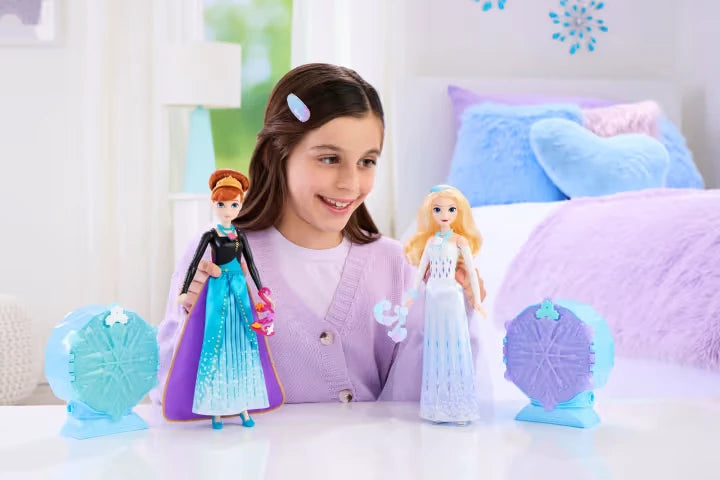 Child playing with Disney Frozen Jewel Reveal Elsa and Anna dolls beside their snowflake gem boxes