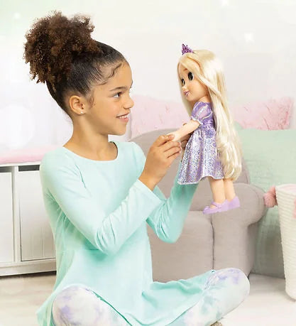 Child playing with Disney Rapunzel Toddler Doll wearing purple dress and tiara in Ireland.