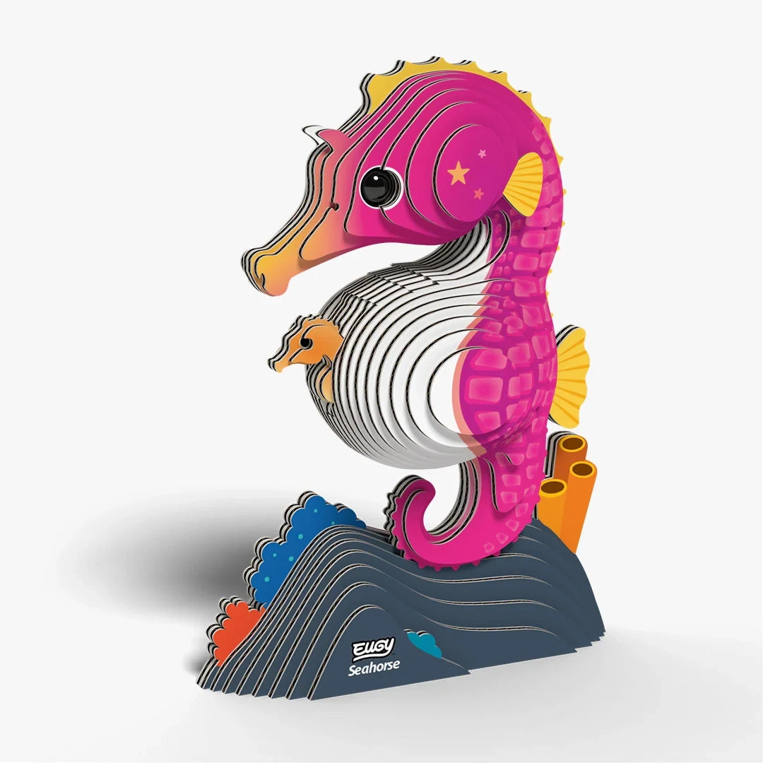 EUGY Seahorse cardboard model angled left showing the layered pink body, yellow fin, baby seahorse and dark blue wave shaped base