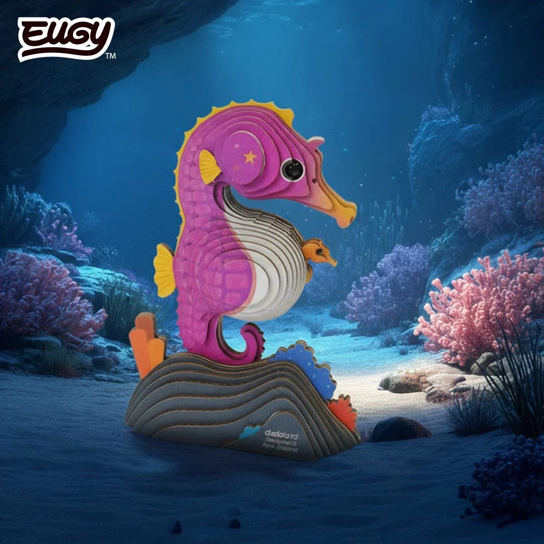 EUGY Seahorse 141 pink cardboard model with curled tail and baby seahorse, displayed among colourful coral in an underwater reef scene