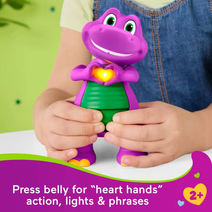 Child pressing Fisher-Price Barney's World Heart Hands Barney with his hands raised around the glowing heart on his chest