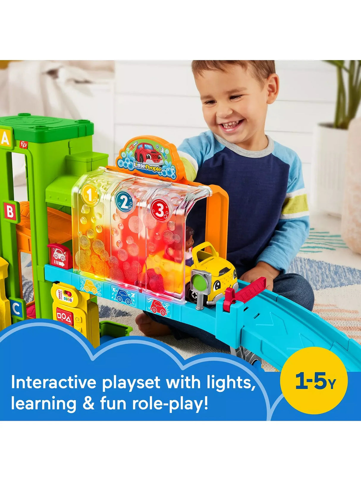 Child laughing as a yellow Fisher Price Little People car moves through the light-up car-wash section of the Learning Garage