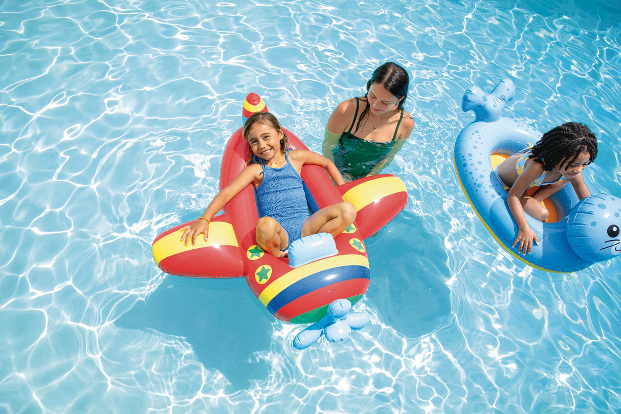 Red plane and blue seal Intex Pool Cruisers floats in a swimming pool with children and an adult