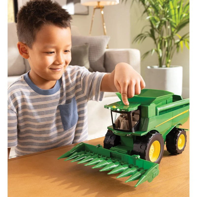 John Deere Lights & Sounds Combine 47714 being played with on a table with the corn head fitted