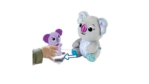 Hand reaching toward baby koala plush beside mummy koala with arrow graphic between them