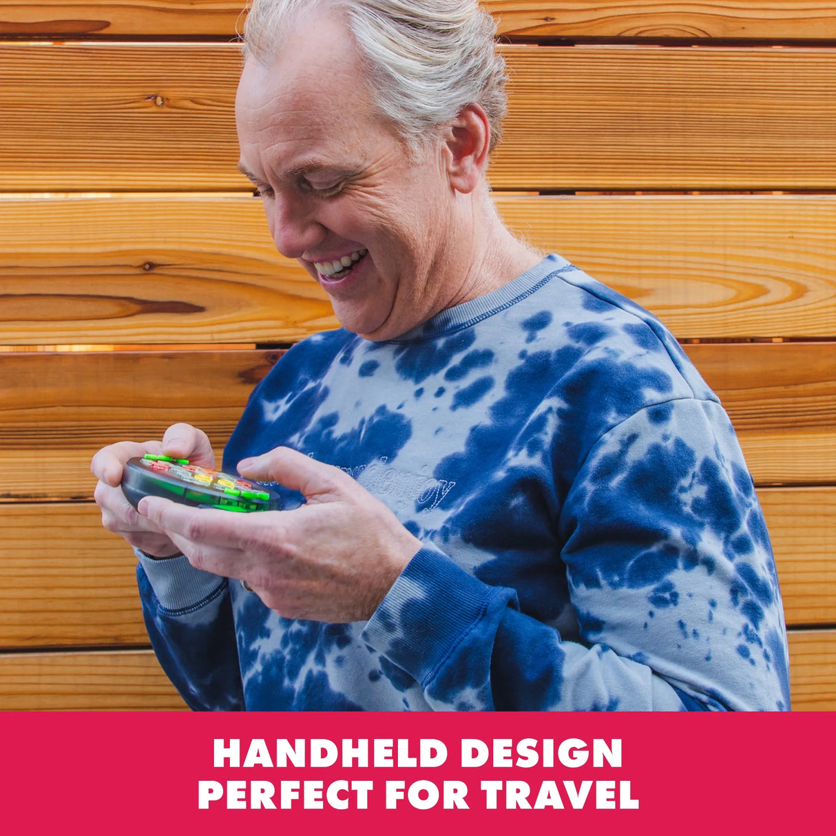 Adult playing Learning Resources BrainBolt handheld memory game outdoors