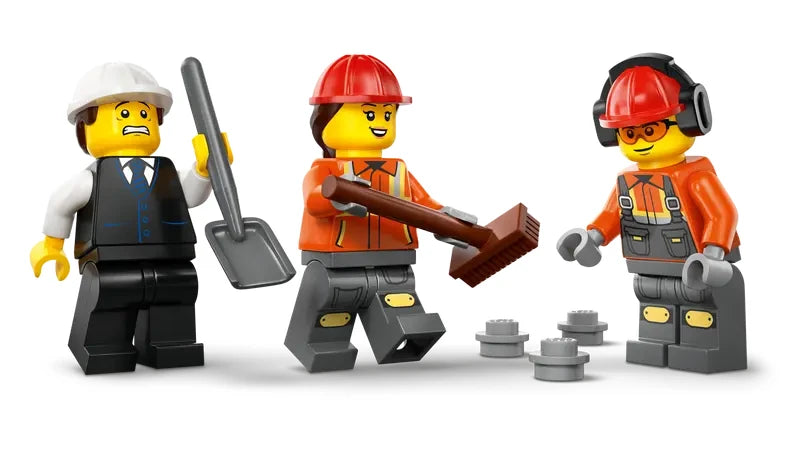 Close up view of three LEGO City construction minifigures wearing safety helmets, shown with brush and shovel.