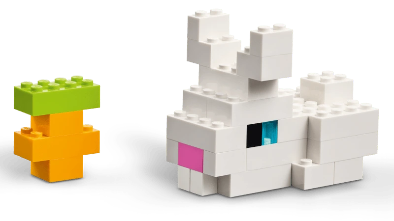 White LEGO animal build beside a small green and orange tree build