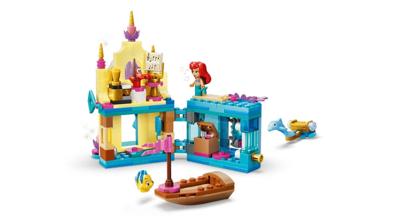 Opened Ariel mini palace showing interior rooms with hinged sections and a small boat placed in front on a white background