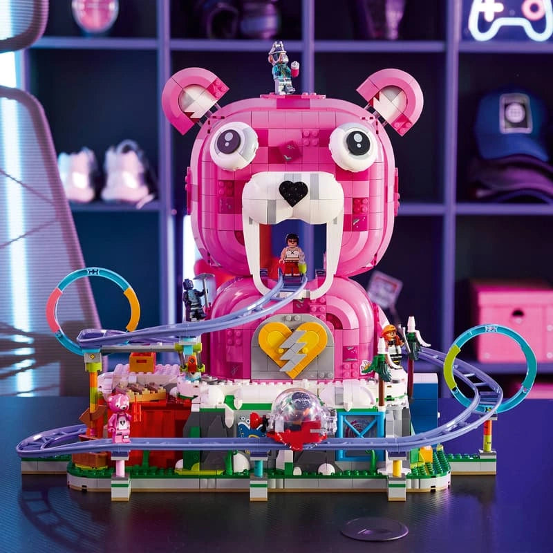 LEGO Fortnite Rave Cave 77082 displayed on a desk in a gaming room, showing the pink bear head, purple roller coaster, colourful loops and Fortnite minifigures.