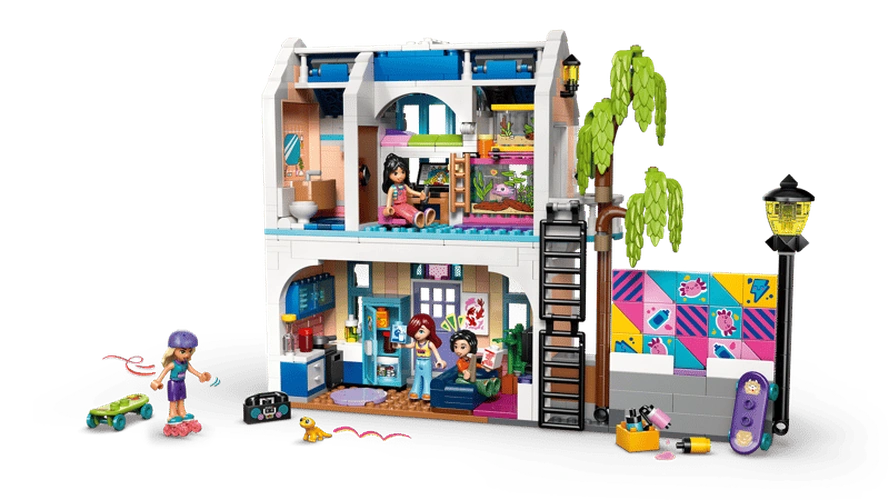 Rear view of LEGO Friends Liann's Family House 42687 showing the open two storey interior, furnished rooms, minidolls, outdoor skate area, climbing ladder and colourful wall mural.