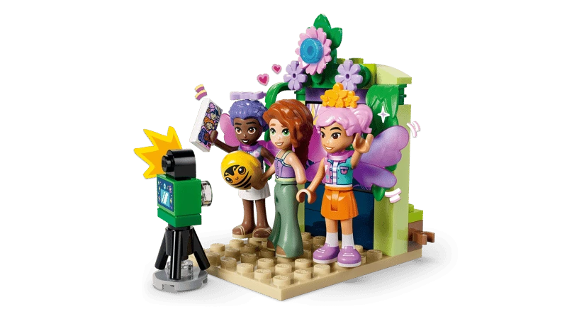 LEGO Friends photo booth scene with three minidolls, camera, flowers and fairy wings