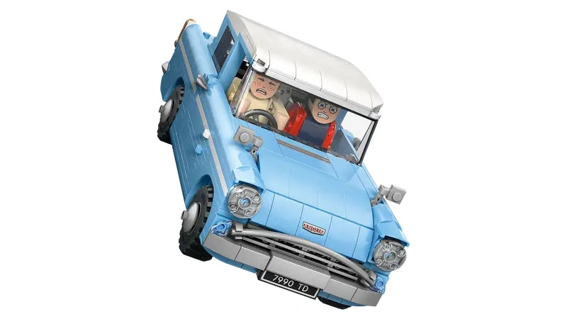 LEGO Harry Potter Enchanted Flying Ford Anglia shown tilted as if flying, with front grille, headlights, white roof, and Harry Potter and Ron Weasley figures visible through the windscreen on a white background