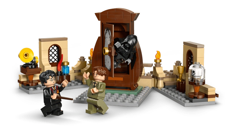 Close up LEGO scene with brown wardrobe opening, black hooded Dementor figure emerging, Harry Potter and another minifigure holding wands, and small display builds with bottles, lamp and glass dome