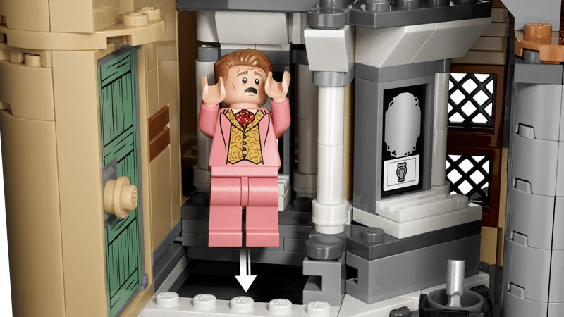 LEGO Hogwarts bathroom section with pink minifigure, green door, grey pillars and downward arrow marker