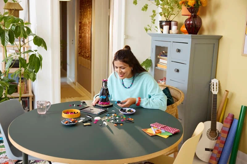 Adult builder assembling the LEGO Ideas La Catrina 21372 model at a table