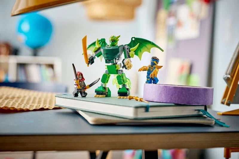 LEGO green dragon mech with ninja minifigures displayed on a notebook