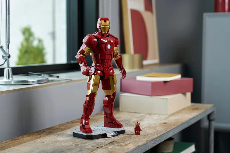 LEGO Iron Man Mark 3 model displayed on a wooden table beside the Iron Man minifigure and stacked books