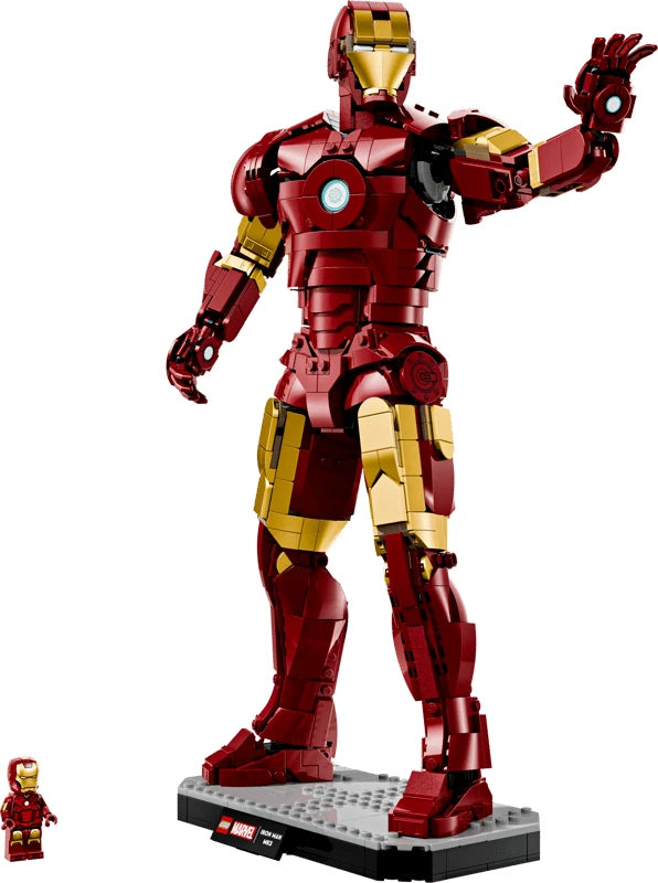 LEGO Iron Man Mark 3 model posed with one hand raised on its display base beside the Iron Man minifigure