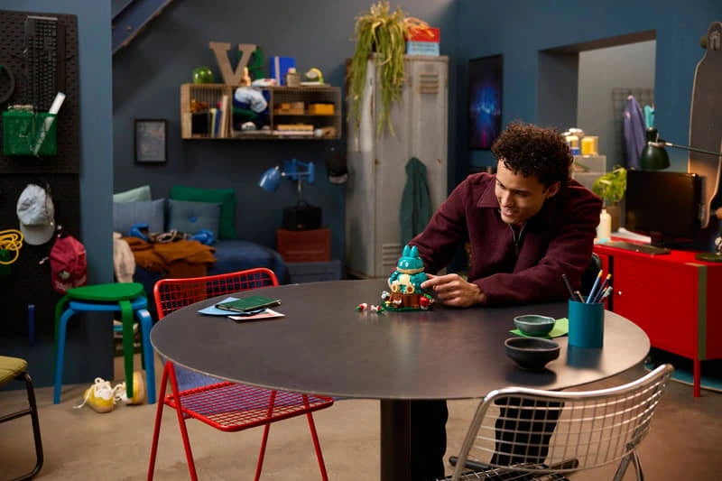 Person positioning the LEGO Pokémon Munchlax 72150 model on a round table