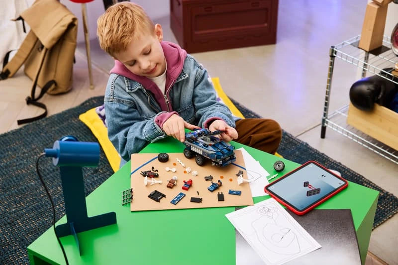 Child building a LEGO Marvel prison transport set at a table with vehicle parts, minifigures and tablet instructions