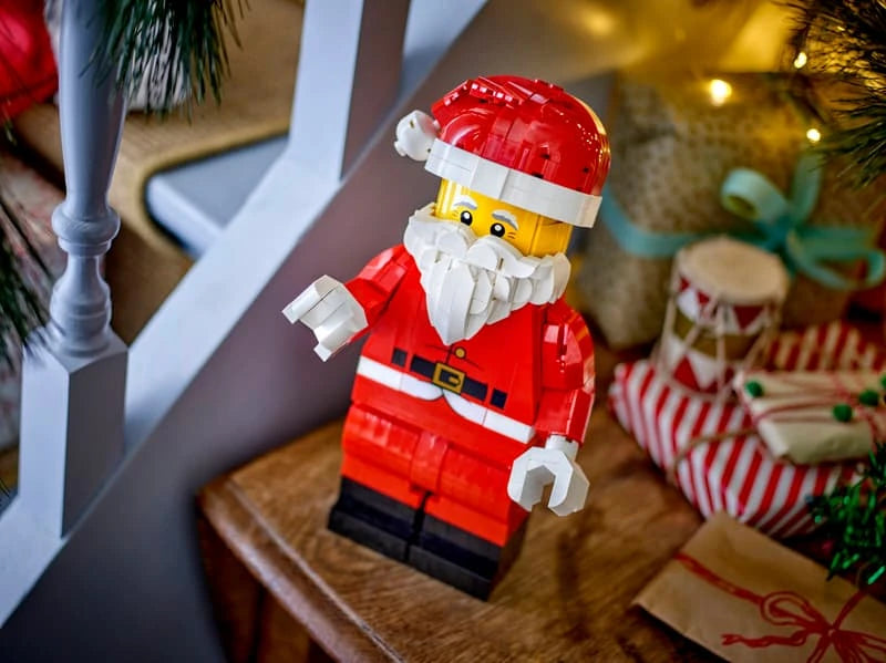 LEGO Santa figure beside a staircase with wrapped presents and Christmas greenery