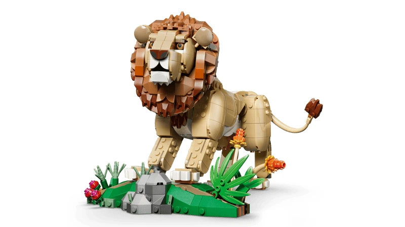 LEGO lion model standing on a savanna habitat build with rocks, plants and flowers