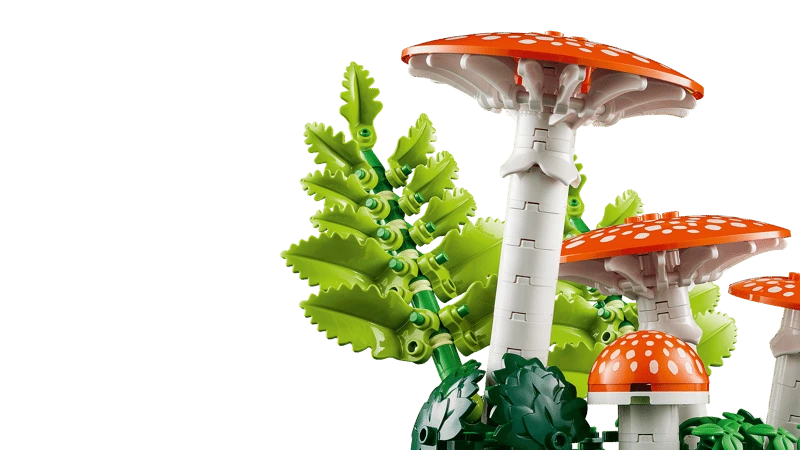 Close up of LEGO red fly agaric mushrooms with white spots and green fern pieces