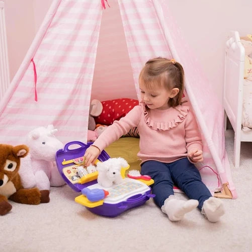 Child sitting beside the open Little Pet Parlour Carry Case with the white plush puppy, grooming tools and purple case arranged for play