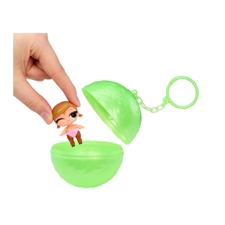 Hand removing a miniature L.O.L. Surprise Bubbly Surprise Baby Sister doll from its green spherical keychain container.