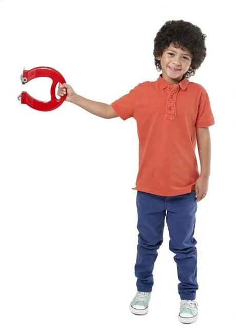 Child holding large red Massive Magnet toy horizontally to demonstrate magnetic strength and lifting power
