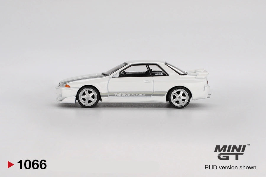 Side profile of Mini GT Nissan Skyline GT-R R32 VeilSide Combat C-I White showing the silver five spoke wheels, grey VeilSide graphics, modified front bumper and raised rear spoiler